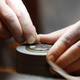 A watchmaker works on a wrist watch. If this doesn’t make sense to you, you haven’t listened to the podcast.